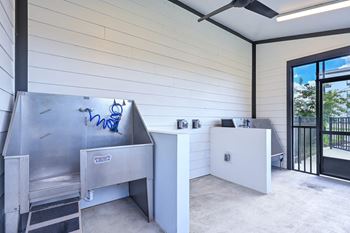 an outdoor kitchen with a grill and a table with chairs at Ironwood Flats, Brandon, 33511